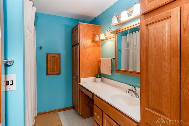 full bath with baseboards and vanity