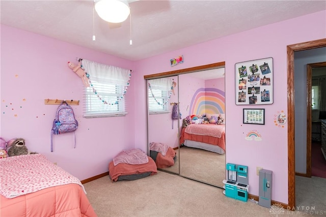 bedroom featuring carpet, baseboards, ceiling fan, and a closet