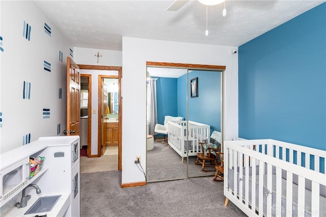 carpeted bedroom featuring ceiling fan, a textured ceiling, baseboards, and a closet