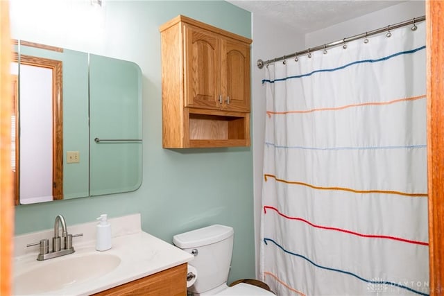 bathroom with toilet, curtained shower, a textured ceiling, and vanity