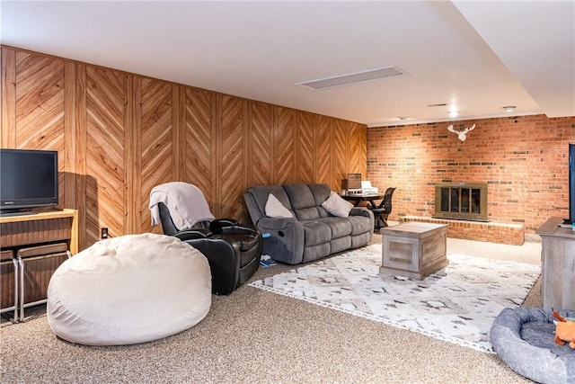 living area featuring carpet floors, a brick fireplace, and wooden walls