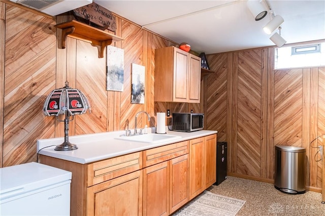 kitchen featuring wooden walls, open shelves, and a sink