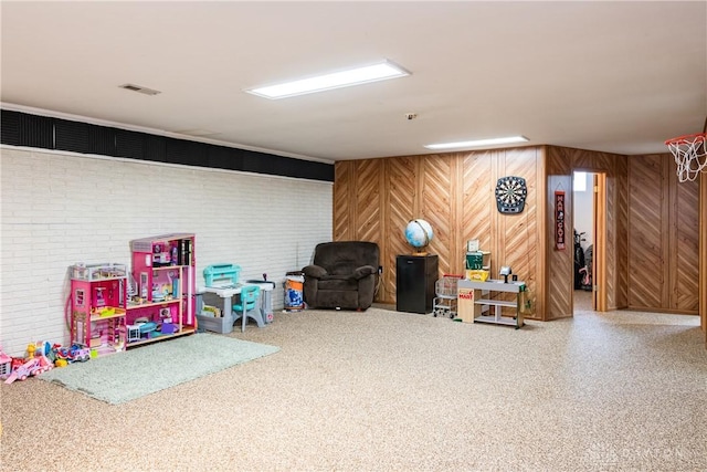 finished basement featuring brick wall and visible vents