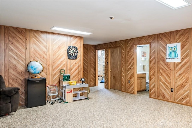 playroom with carpet floors and wooden walls