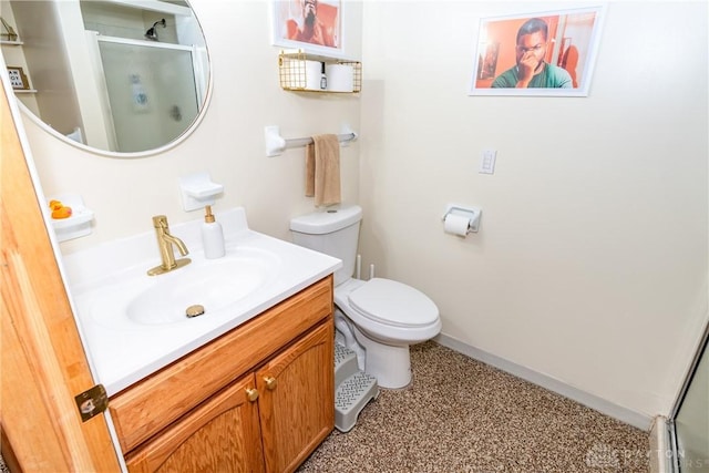 bathroom featuring a stall shower, baseboards, vanity, and toilet