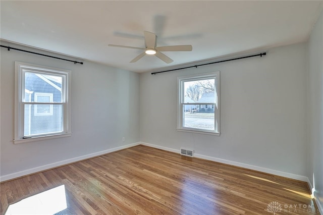 spare room with light wood-style floors, visible vents, and baseboards