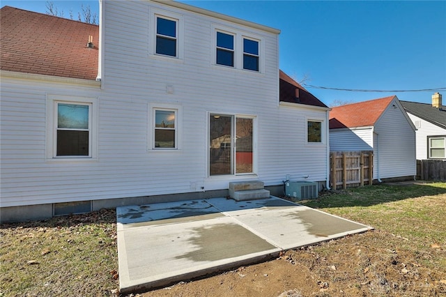 back of house featuring entry steps, a patio, central air condition unit, fence, and a lawn