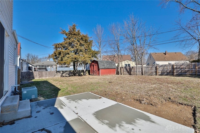 view of yard with a fenced backyard, a storage unit, an outdoor structure, and a patio