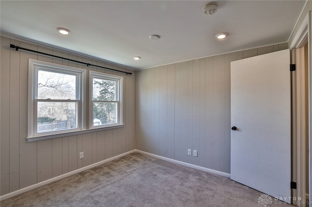 empty room featuring carpet and baseboards