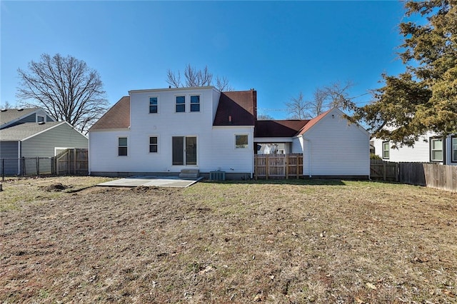 back of house featuring central air condition unit, a patio area, a fenced backyard, and a lawn