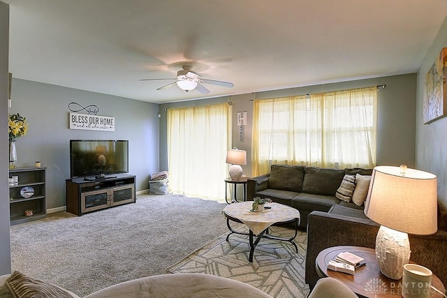 carpeted living room featuring ceiling fan and baseboards