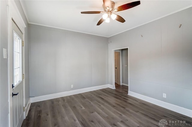 empty room with ceiling fan, crown molding, baseboards, and wood finished floors