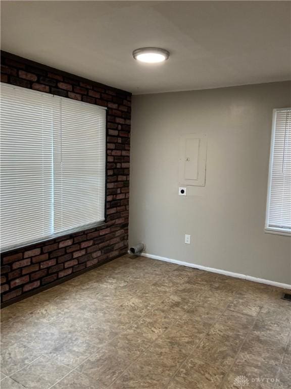 spare room featuring electric panel and baseboards