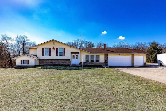 split level home featuring a garage, brick siding, concrete driveway, a chimney, and a front yard