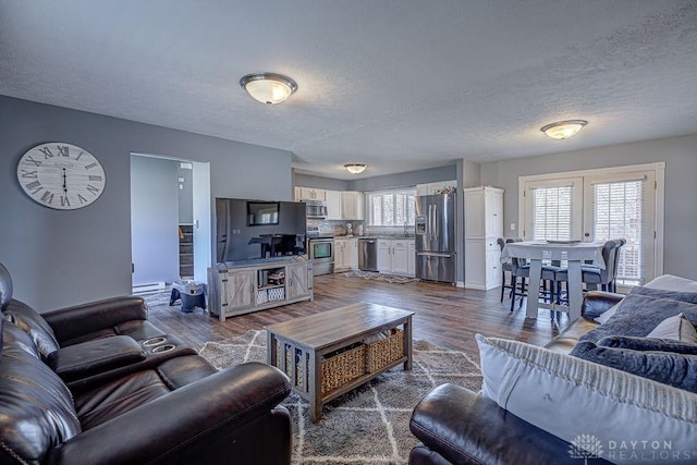 living room featuring dark wood-style flooring and a textured ceiling