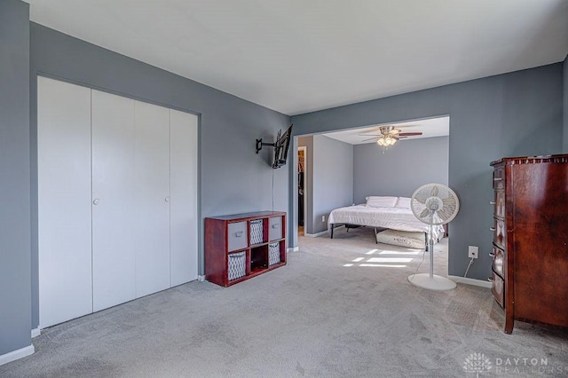 carpeted bedroom featuring a closet, ceiling fan, and baseboards