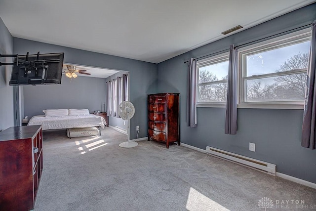 bedroom featuring a baseboard heating unit, carpet flooring, visible vents, and baseboards