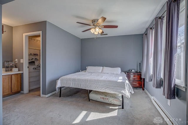 bedroom featuring a baseboard heating unit, light carpet, ceiling fan, and baseboards