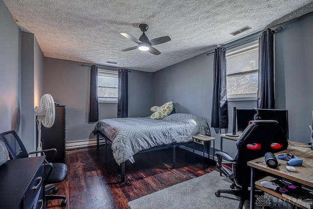 bedroom with wood-type flooring, visible vents, and ceiling fan