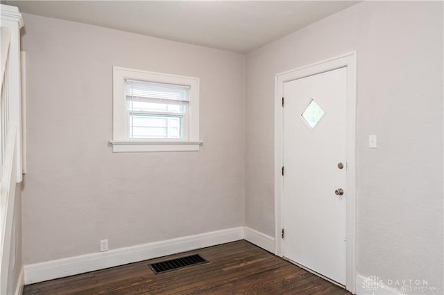 foyer featuring baseboards, visible vents, and dark wood finished floors