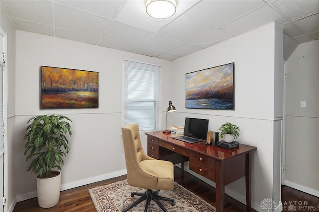 office space featuring a paneled ceiling, baseboards, and wood finished floors