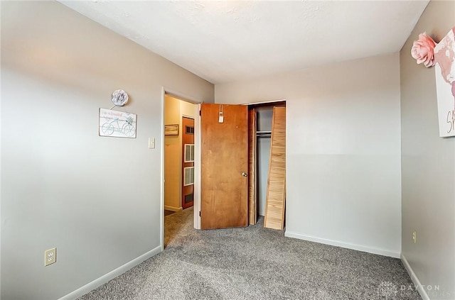 unfurnished bedroom with carpet floors, baseboards, and a closet