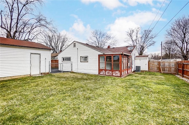 back of property featuring a yard, cooling unit, a fenced backyard, and a gate