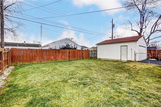 view of yard with an outbuilding, a fenced backyard, and a detached garage