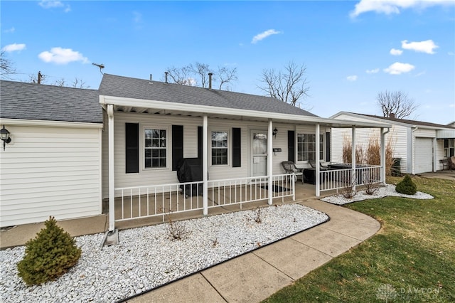 single story home featuring covered porch, roof with shingles, and an attached garage