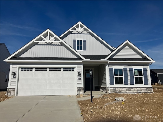 craftsman inspired home featuring driveway, stone siding, an attached garage, and roof with shingles