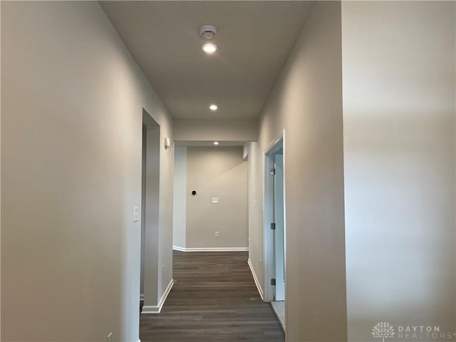 hallway with dark wood-type flooring, recessed lighting, and baseboards