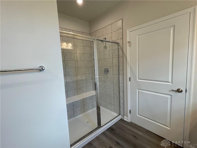 bathroom with a stall shower and wood finished floors