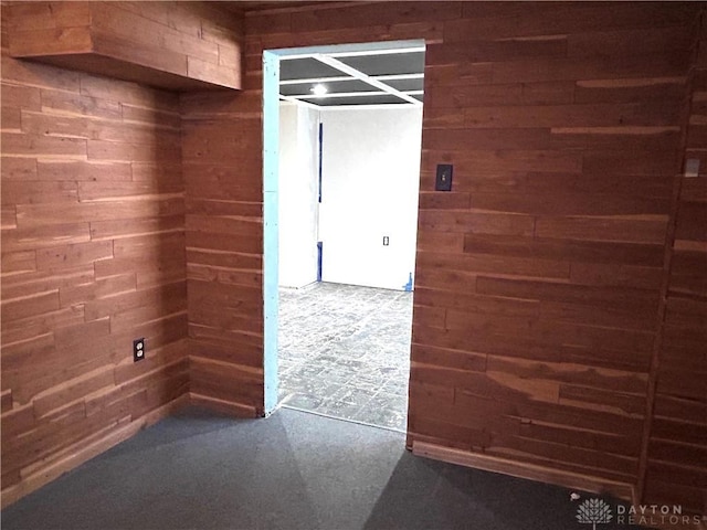 empty room featuring concrete floors and wooden walls