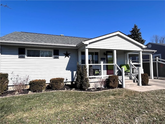 view of front of property featuring a porch, roof with shingles, and a front lawn