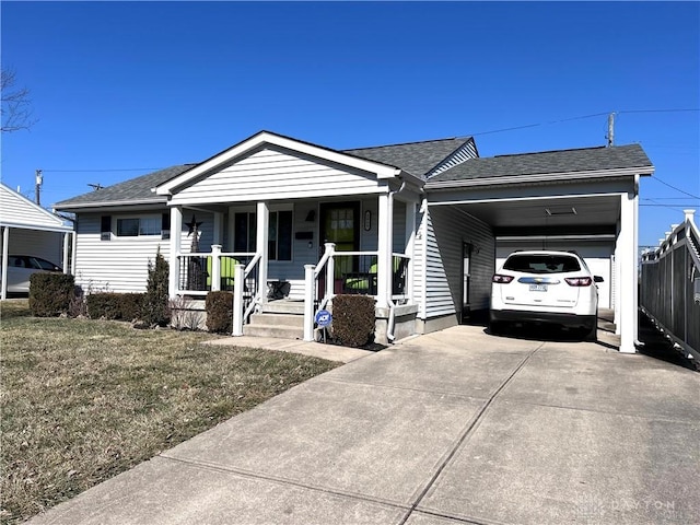 view of front of home with covered porch, a shingled roof, fence, concrete driveway, and a carport