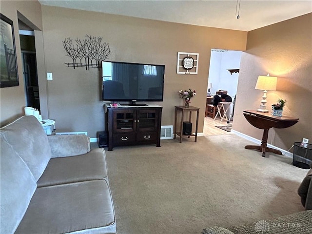 living area with carpet, visible vents, and baseboards