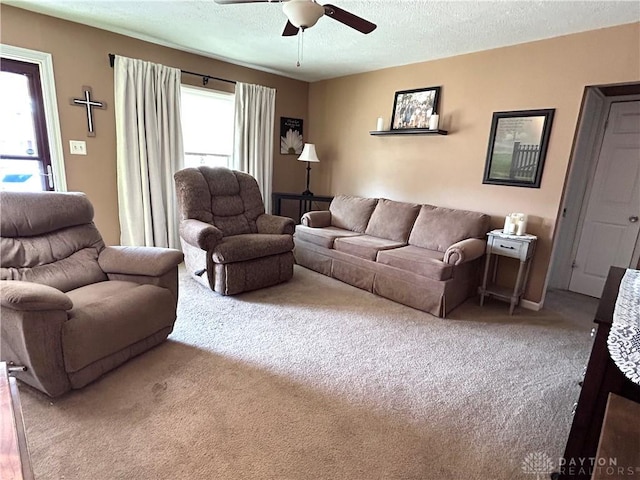 carpeted living room featuring a textured ceiling and a ceiling fan