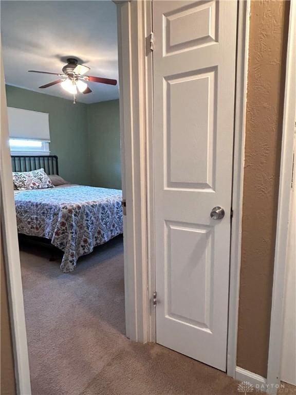 bedroom with carpet floors, a textured wall, and ceiling fan