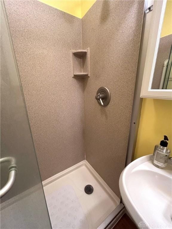 bathroom featuring a stall shower and a sink