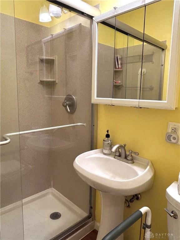 full bathroom with a shower stall and toilet