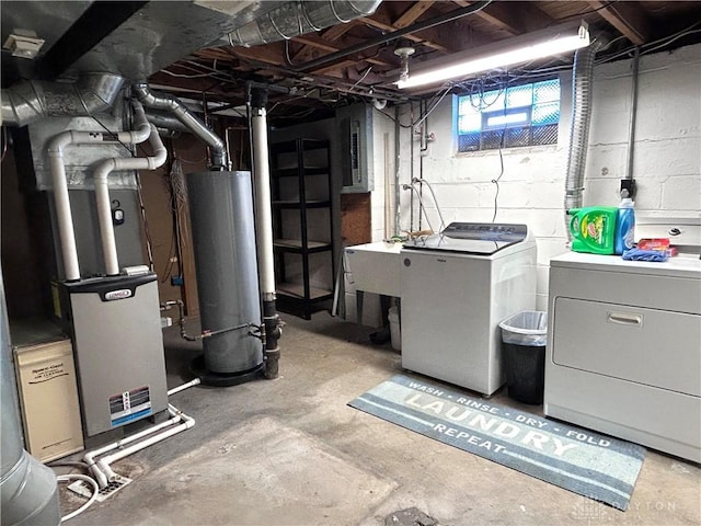 below grade area featuring electric panel, washing machine and clothes dryer, heating unit, water heater, and a sink