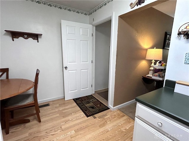 interior space featuring light wood finished floors and baseboards