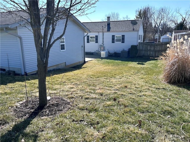 view of yard with central AC and fence