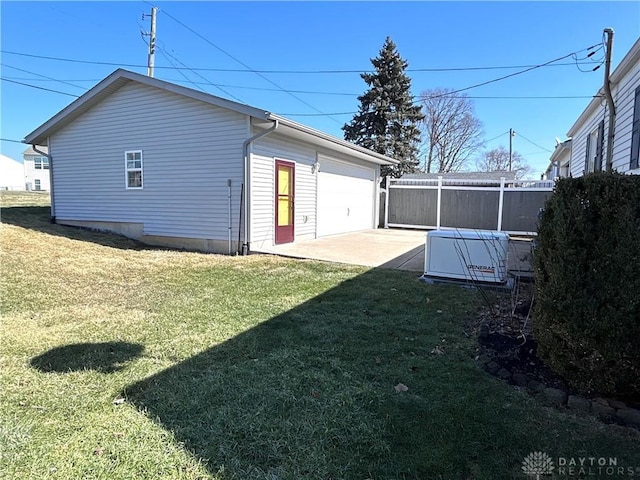 exterior space featuring a yard, a patio area, fence, a garage, and driveway