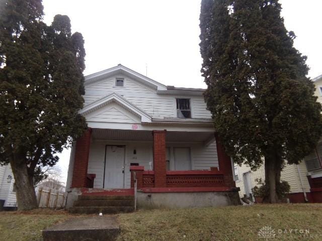 view of front of house with a front yard and covered porch