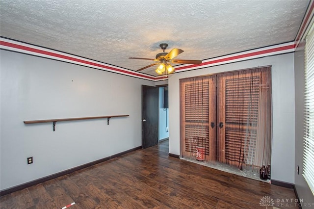 unfurnished room with a textured ceiling, ceiling fan, wood finished floors, and baseboards