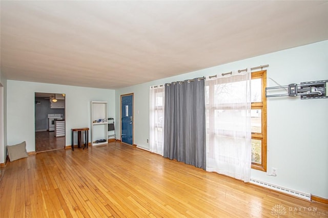 unfurnished room featuring a baseboard radiator and hardwood / wood-style floors