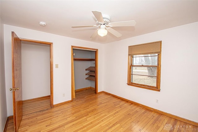 unfurnished bedroom with light wood-style floors, a closet, baseboards, and a ceiling fan