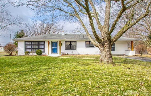 ranch-style home featuring a front lawn and a chimney