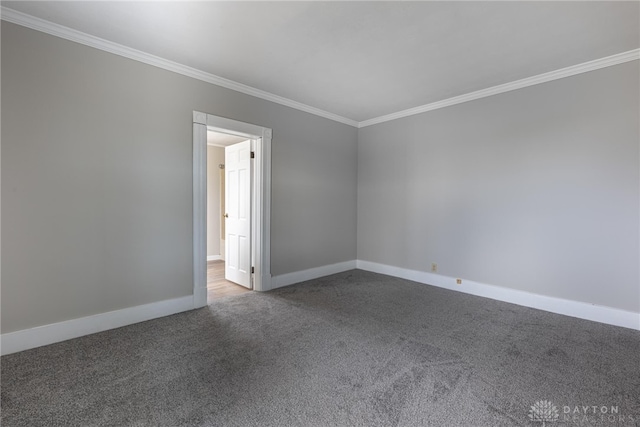 carpeted empty room with baseboards and crown molding